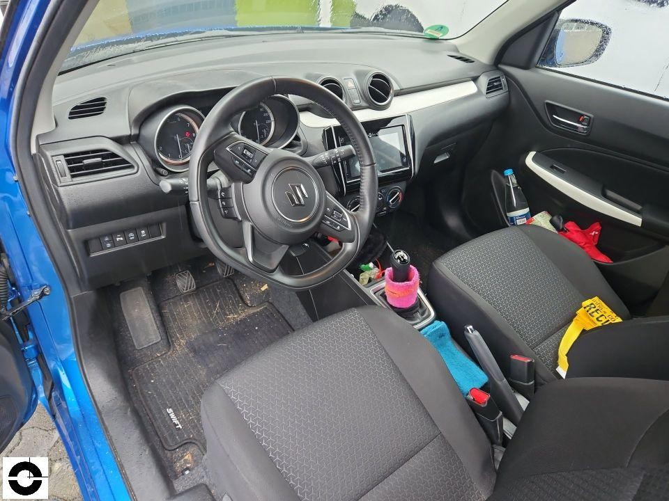 Innenraum Suzuki Swift, Blick durch geöffnete Fahrertür auf Cockpit und Sitze