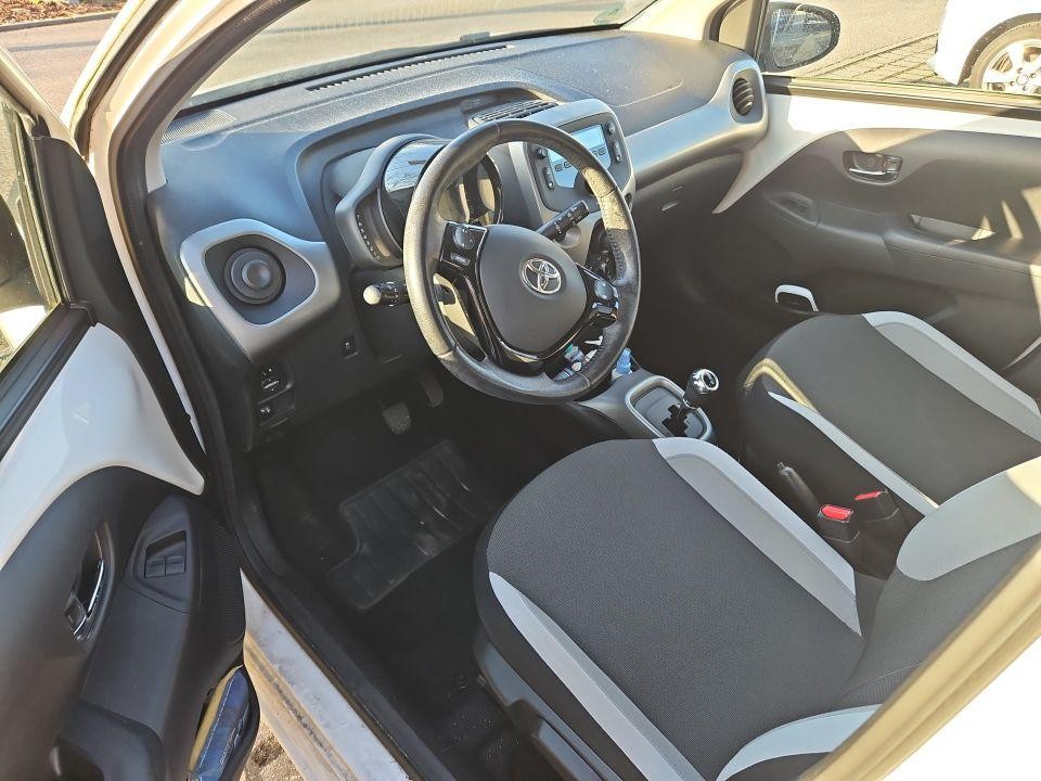 Innenraum Toyota, Blick durch offene Fahrertür auf Cockpit und Vordersitze