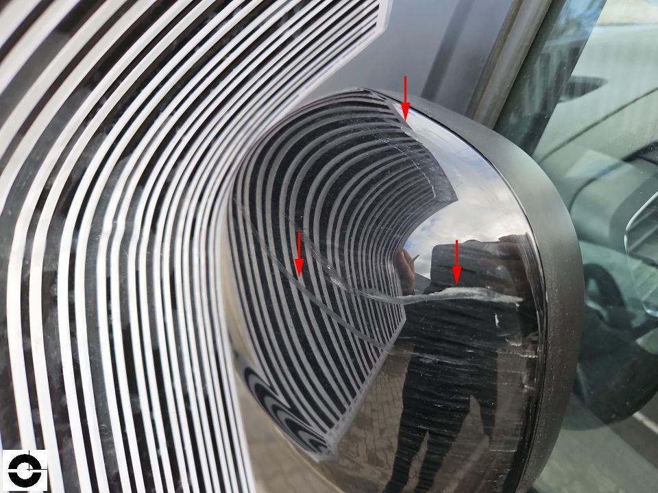 Außenspiegel rechts mit Kratzern, Detailaufnahme mit Streifenlicht-Reflexion zur Schadensdarstellung