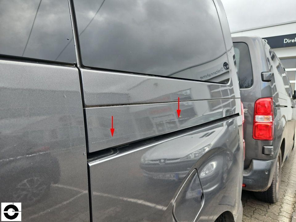 Heckansicht mit roten Pfeilen auf Kratzer an linker Seitenwand und Heckklappe