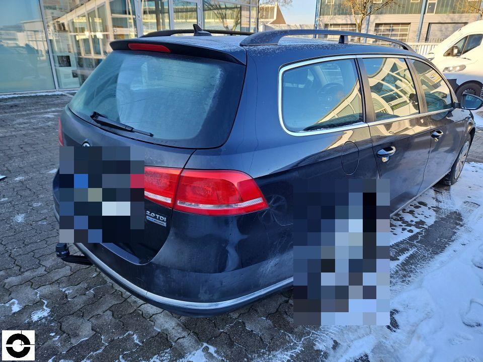 Heckansicht schräg links, dunkelblaues Kombi, Kennzeichen bereits pixeliert, winterliche Parkplatzsituation