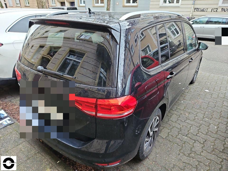 Heckansicht schräg rechts, dunkler Van, keine sichtbaren Schäden, Kennzeichen pixeliert