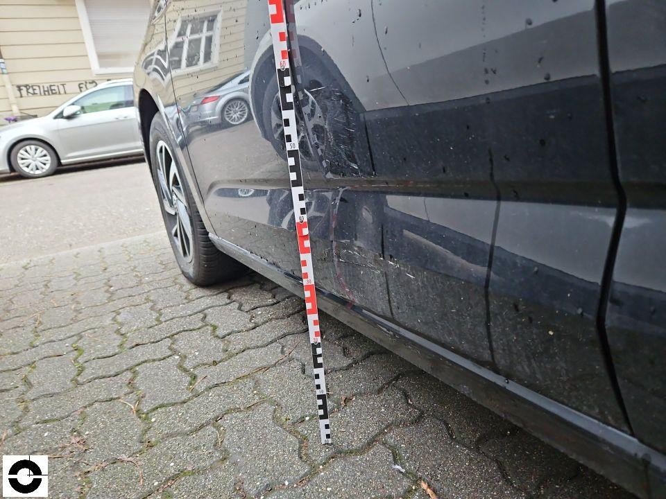 Seitenansicht rechts, Kratzer und Schürfspuren an hinterer Tür mit Messlatte dokumentiert
