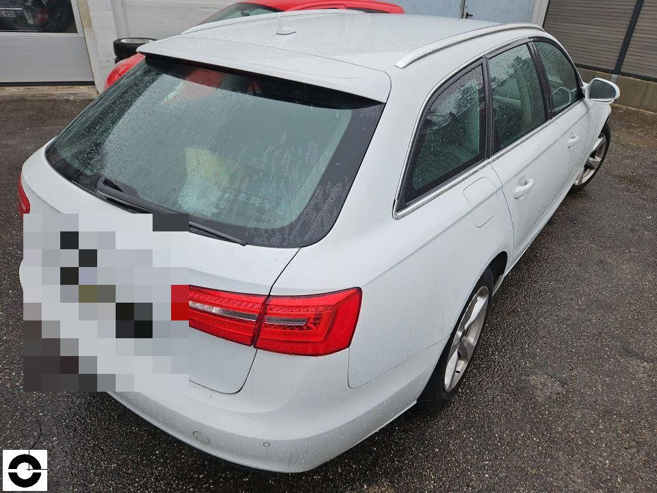 Heckansicht schräg von links, weißer Kombi mit Regentropfen, Kennzeichen pixeliert