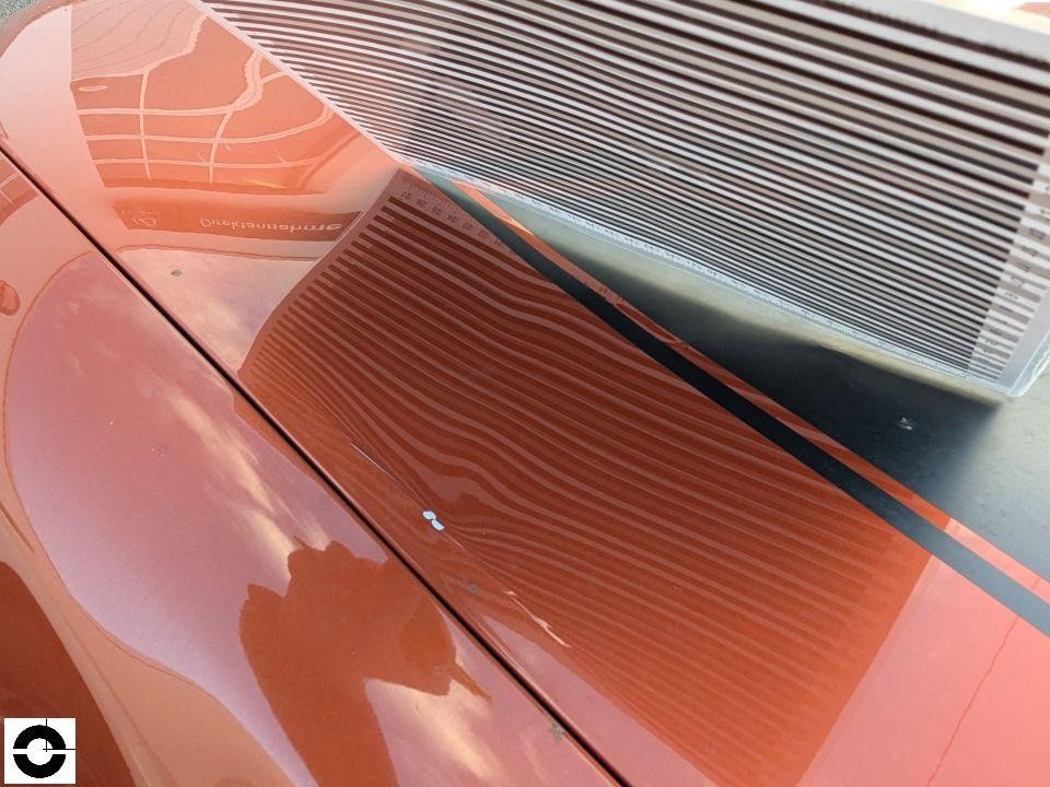 Detailaufnahme Heckscheibe mit Heizstreifen, orangefarbene Lackierung, leichte Verschmutzung sichtbar