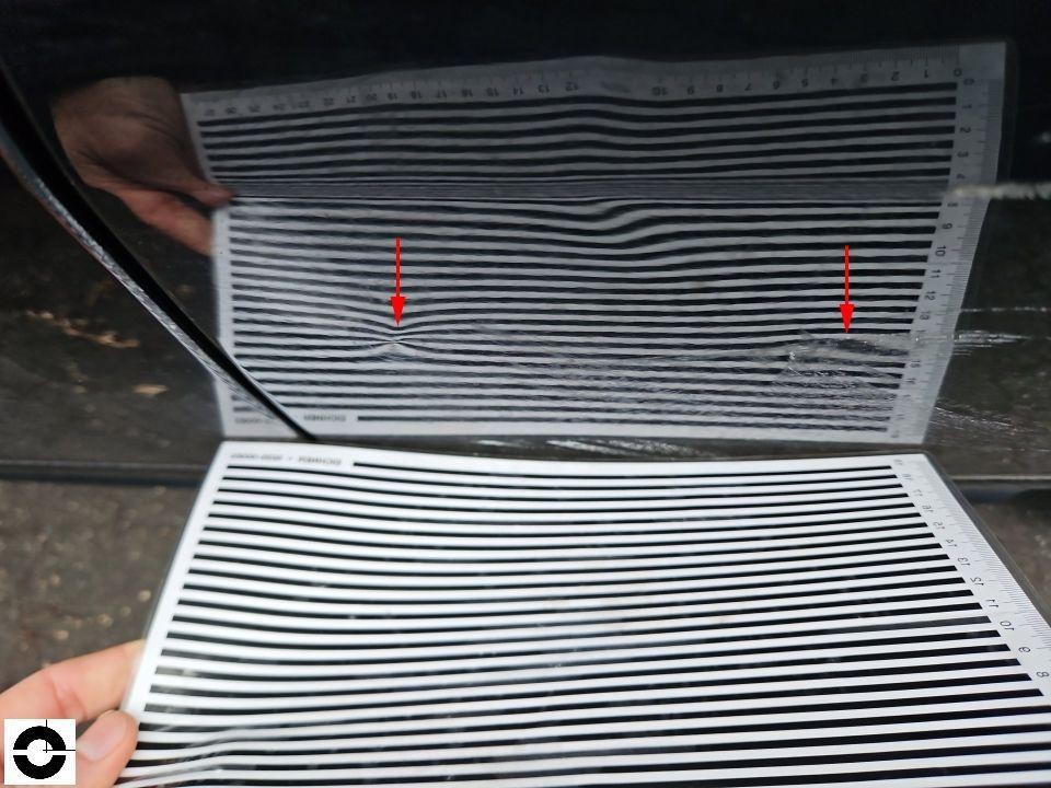 Dellenprüfung mit Streifenlichtfolie, rote Pfeile markieren Dellen auf Karosseriefläche