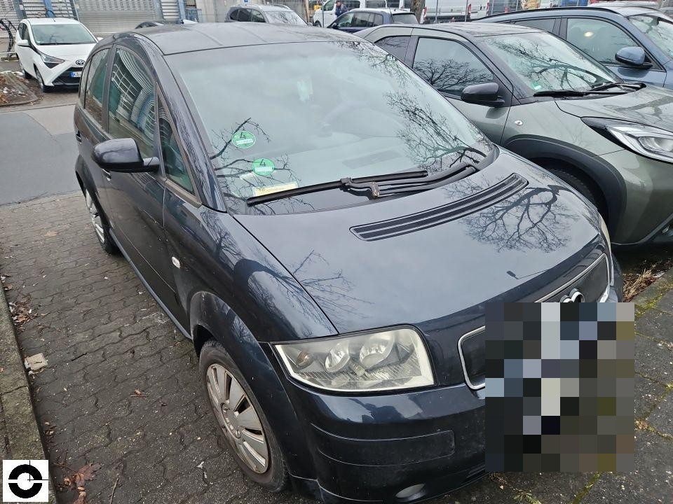 Frontansicht schräg von links, dunkelblaues Fahrzeug auf Parkplatz, keine sichtbaren Schäden