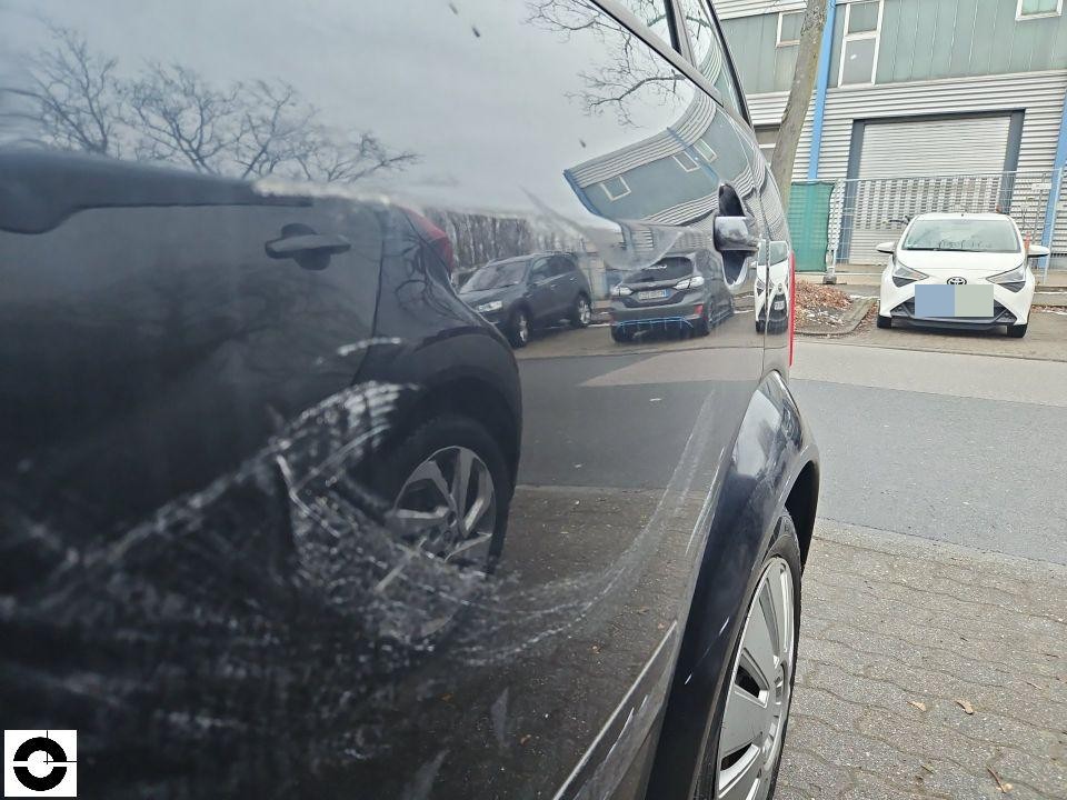 Seitenansicht linke Fahrzeugseite mit Kratzern an hinterer Tür und Kotflügel