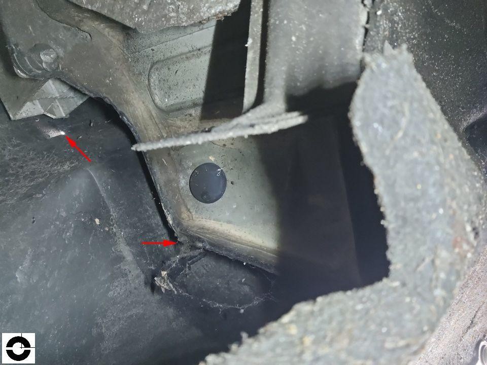 Detailaufnahme Unterboden/Schwellerbereich mit Rissen und Beschädigungen, rote Pfeile markieren Schadenstellen