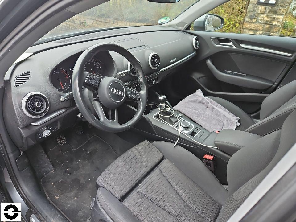 Innenraum Fahrerseite, schwarze Stoffsitze, Lenkrad mit Audi-Logo, Mittelkonsole mit Schaltknauf