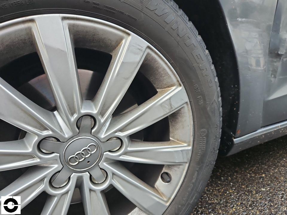 Nahaufnahme linkes Hinterrad mit Audi-Alufelge und Winterreifen, leichte Verschmutzung