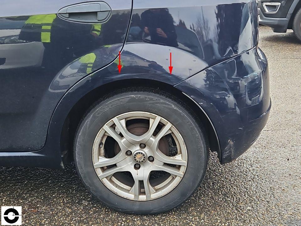 Hinterer linker Kotflügel mit Dellen und Kratzern, rote Pfeile markieren Schadenstellen
