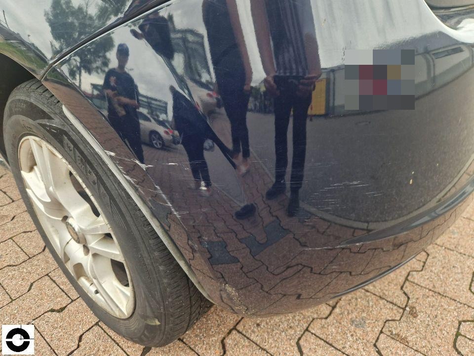 Hinterer linker Kotflügel mit deutlichen Kratzern auf schwarzem Lack