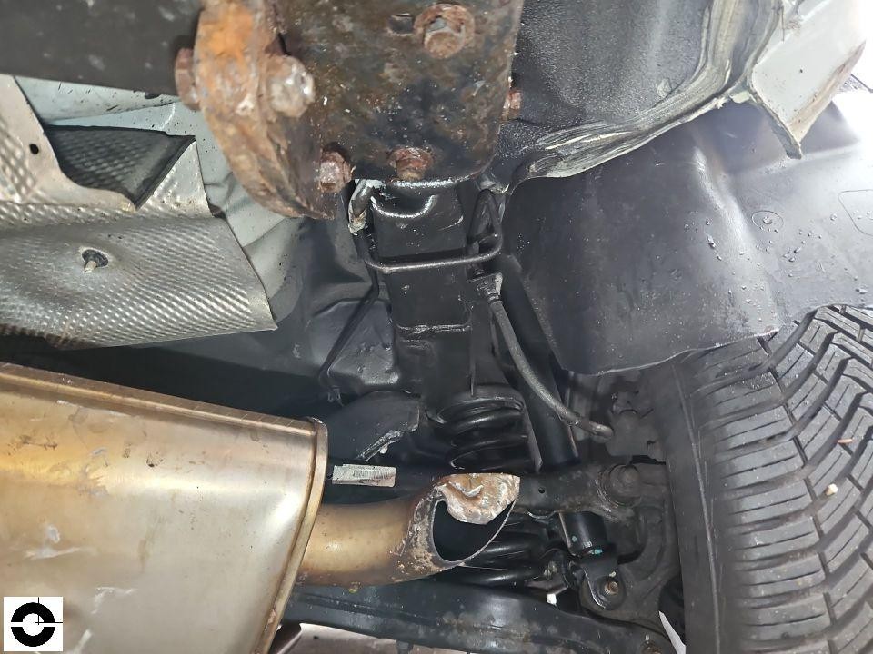 Unterboden-Ansicht, hintere Achse mit Stoßdämpfer, Feder und Auspuffendrohr, starke Rostbildung sichtbar