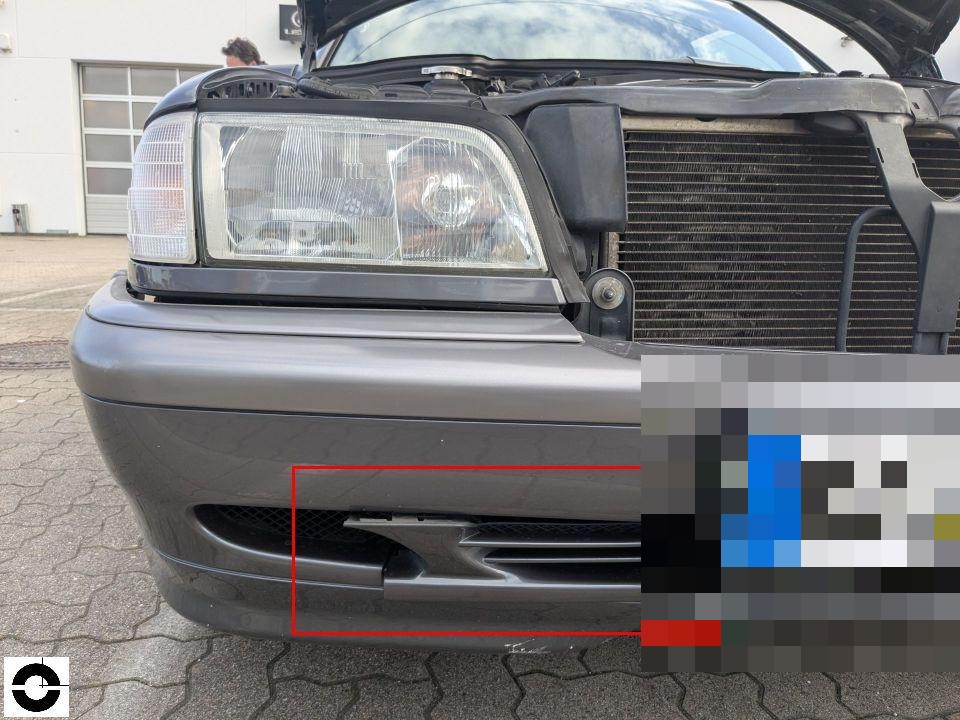 Frontansicht, geöffnete Motorhaube, Stoßfänger mit rot markiertem Schaden an Lüftungsgitter links