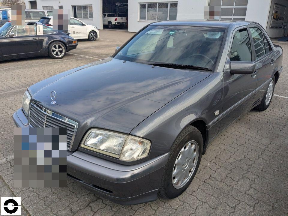 Frontansicht schräg von links, dunkelgrauer Mercedes C-Klasse W202, keine sichtbaren Schäden