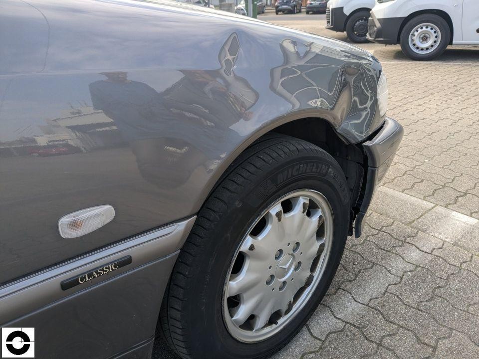 Seitenansicht linker vorderer Kotflügel mit starker Delle und Verformung oberhalb Radlauf