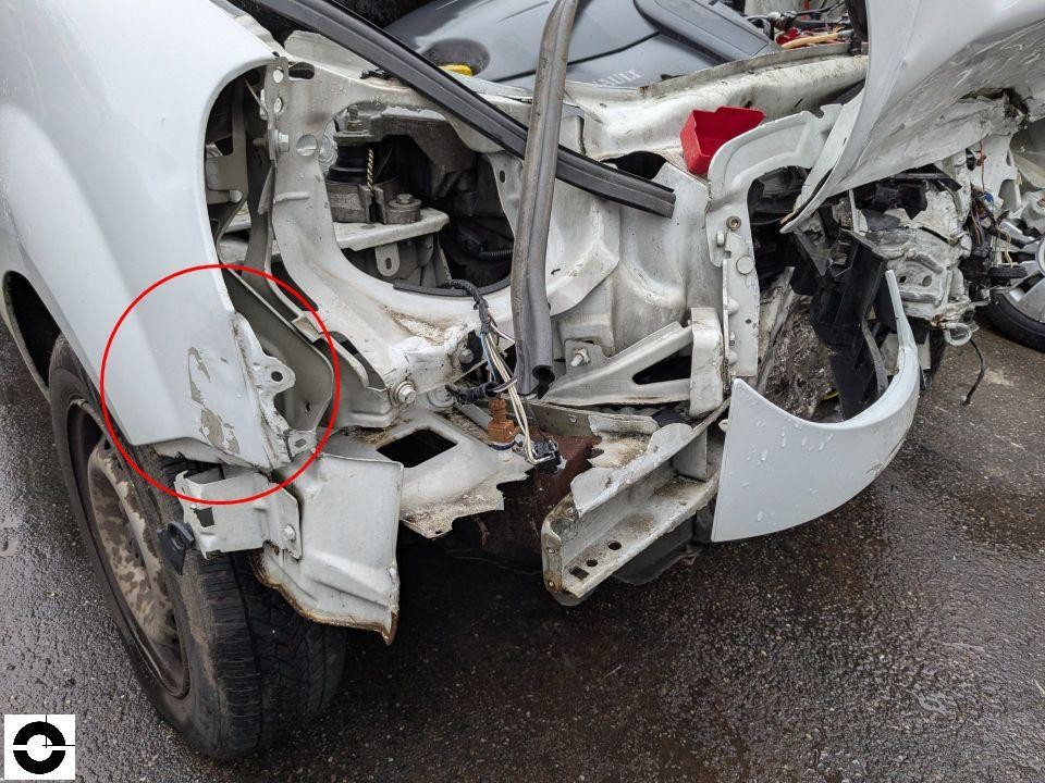 Schwerer Frontschaden links, Karosseriestruktur freigelegt, roter Markierungskreis am Längsträger