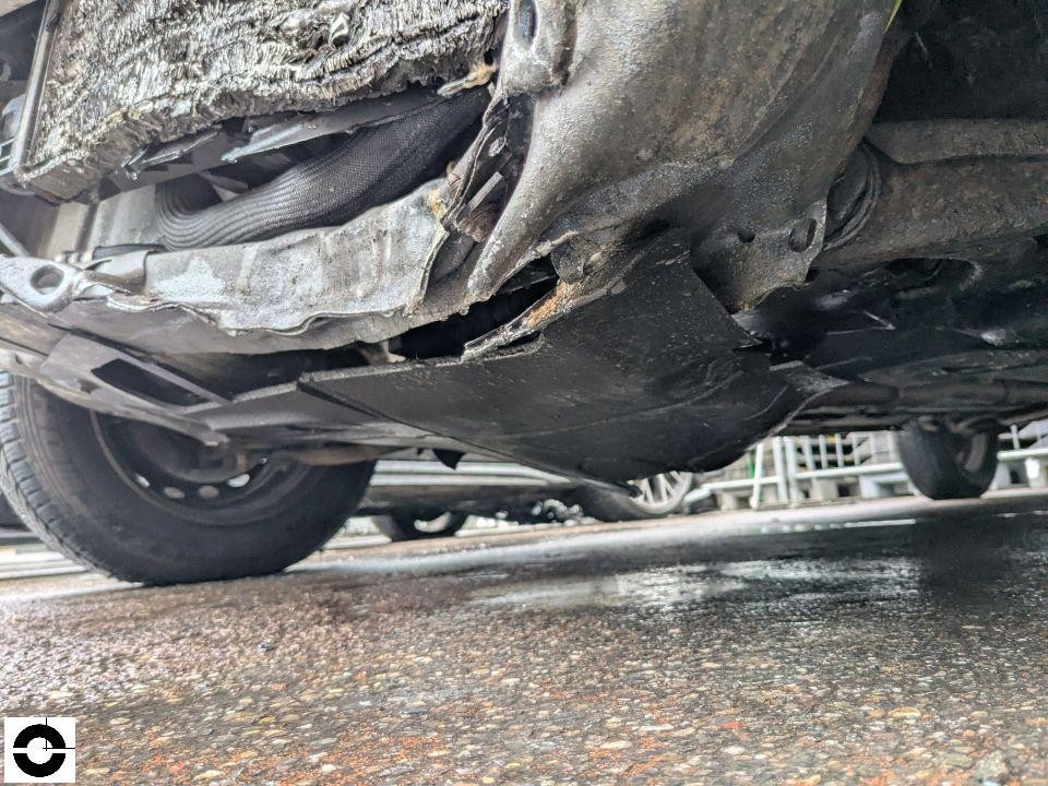 Unterboden-Ansicht, schwere Schäden an Unterbodenverkleidung und Frontbereich von unten