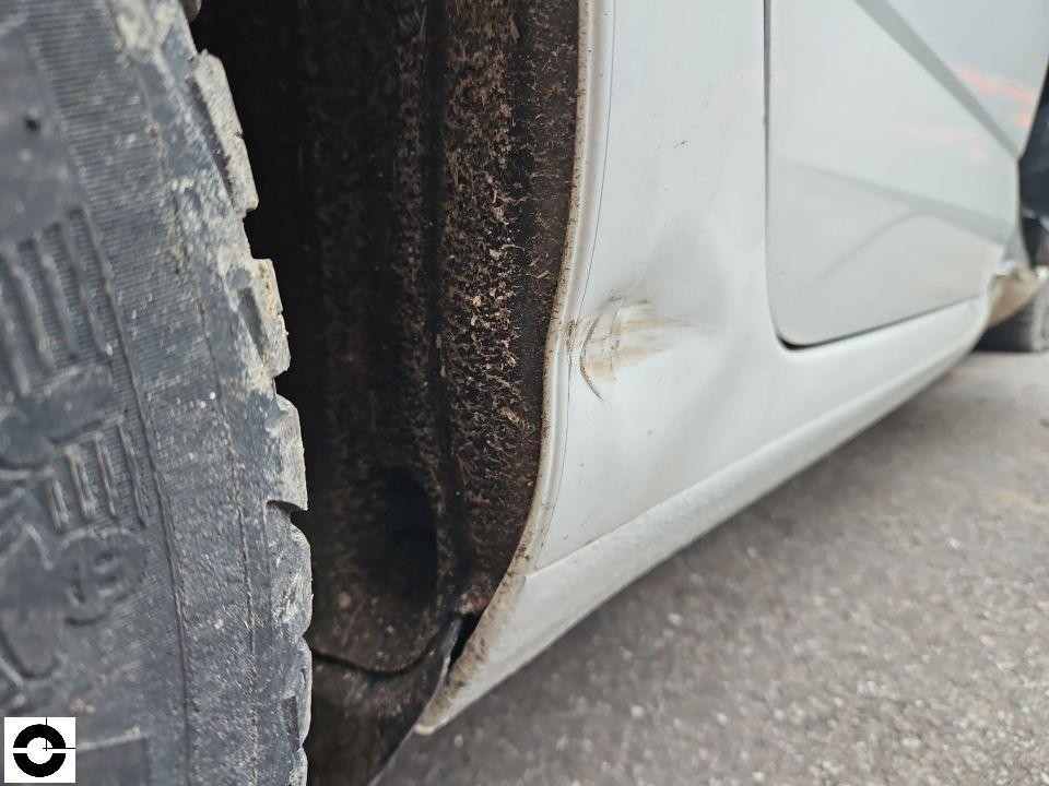 Nahaufnahme Schweller links hinten mit Schmutz und Kratzspuren am Radlauf