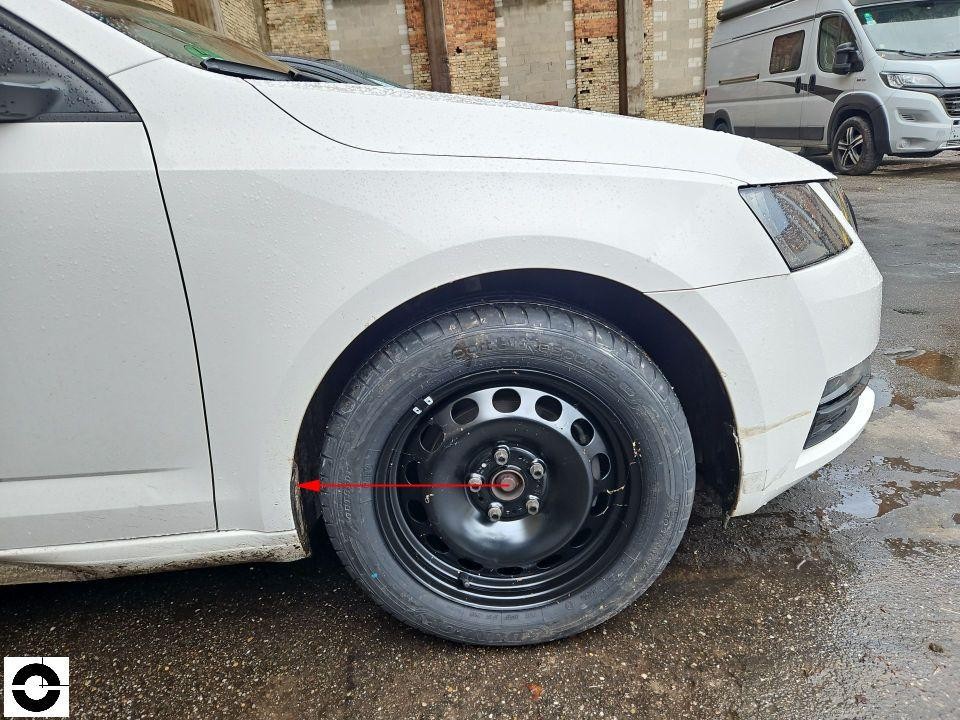Vorderes rechtes Rad mit Stahlfelge, roter Markierungspfeil auf Radnabe