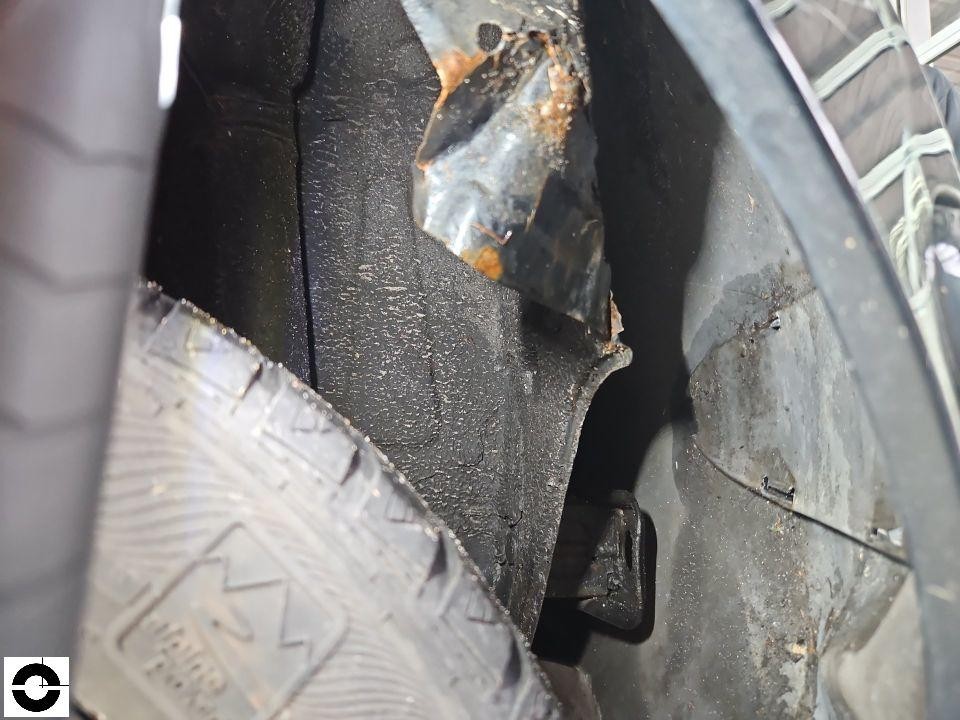 Detailaufnahme Radkasten mit Rostschaden und verbogenem Blech am Kotflügel