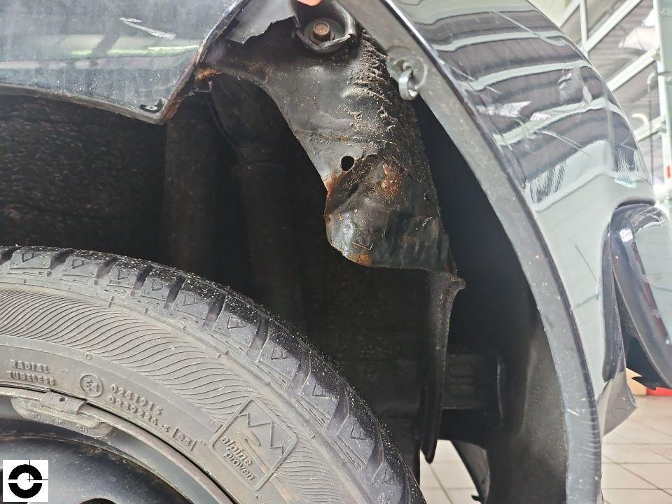 Detailaufnahme Radkasten vorne links mit beschädigter Radhausschale und Rostansatz