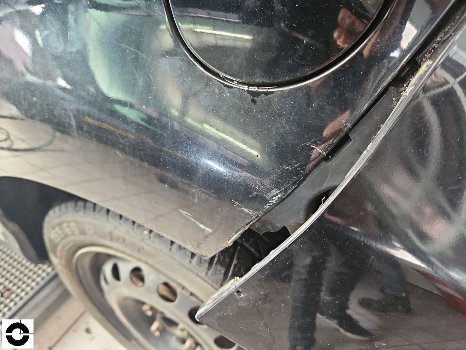 Hinterer linker Kotflügel mit Kratzern und Lackabplatzungen, Tankdeckelbereich sichtbar