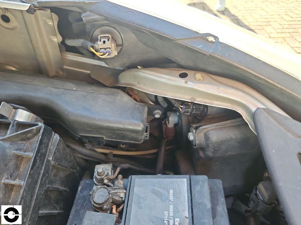 Motorraum mit Batterie, Kabelverbindungen und Scharnierbereich der Motorhaube