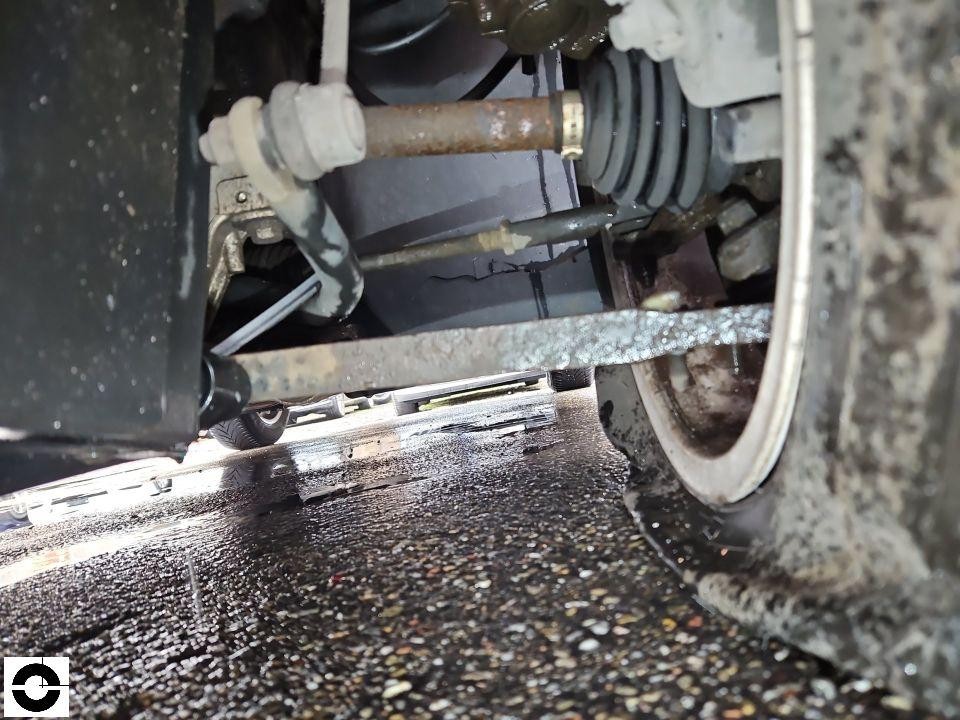 Unterboden-Ansicht mit Antriebswelle, Achsmanschette und Fahrwerkskomponenten, Ölspuren sichtbar